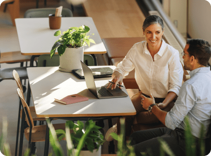 Two people sitting at a table looking at a computer