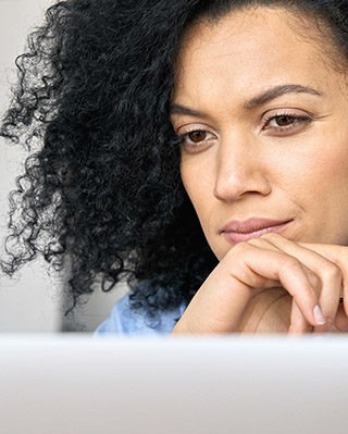 Closeup portrait of serious African American businesswoman using laptop.